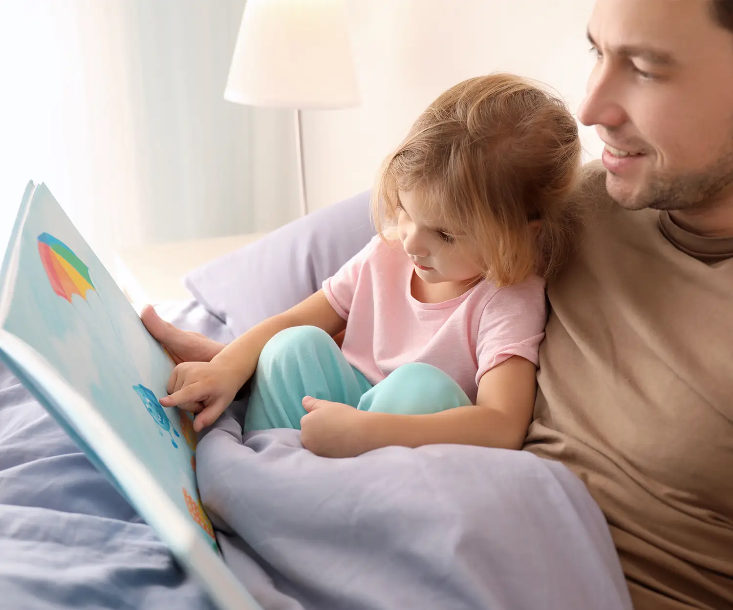 Man leest verhaal voor aan zijn dochtertje.